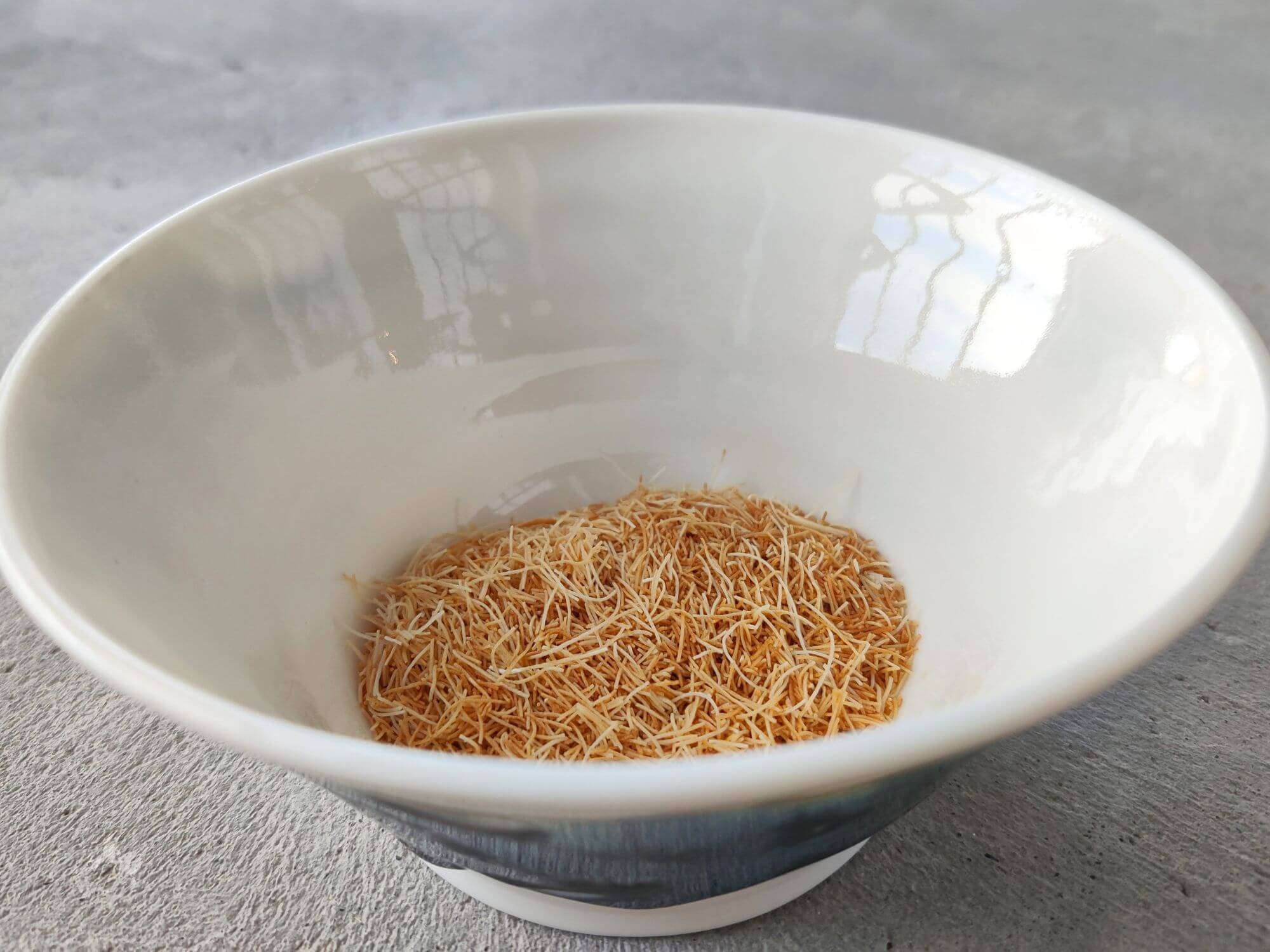 Toasted Kataifi pastry in a white bowl.