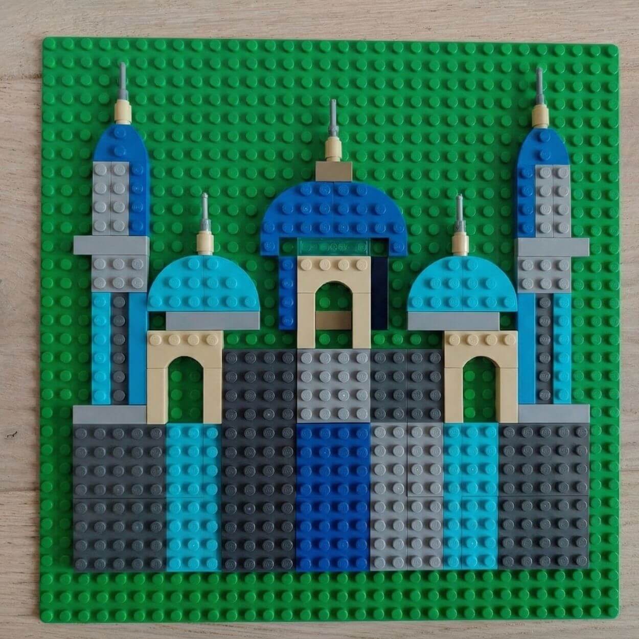 LEGO mosque silhouette built on a green baseplate with blue domes and symmetrical minarets using standard LEGO bricks